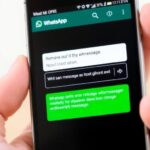 Smartphone com interface do WhatsApp e mão segurando.