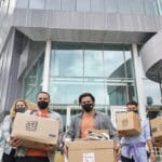 Profissionais de tecnologia tristes com caixas fora do escritório