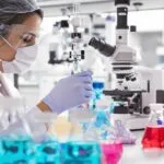 Cientista trabalhando em laboratório com equipamentos.