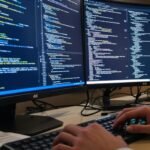 Programador trabalhando com monitores 4K.
