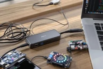 Vários hubs USB-C conectados a laptop em mesa de madeira