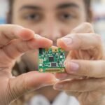 Pessoa interage com placa pequena em laboratório