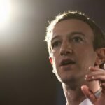 Zuckerberg gesticulando, semblante sério, em conferência de imprensa.
