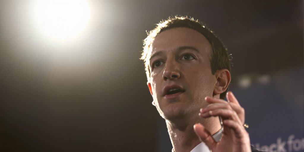 Zuckerberg gesticulando, semblante sério, em conferência de imprensa.