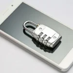 Celular branco com um cadeado em cima, simbolizando a proteção do 2FA